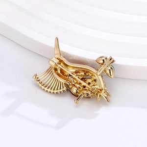 Élégante broche oiseau dorée avec pierres précieuses et fermoir de sécurité sur socle