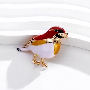 Detailansicht der Vogelbrosche mit roter, weißer, gelber Emaille und Goldlegierung