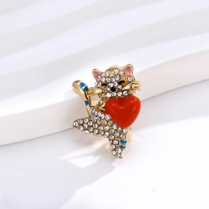 Gros plan d'une broche chat mignonne avec strass brillants et un cœur rouge
