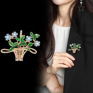 Elegant gold flower basket brooch with blue enamel petals and pearls on a blazer