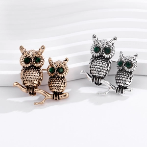 Vintage owl brooch set in antique gold and silver with green rhinestone eyes on a branch