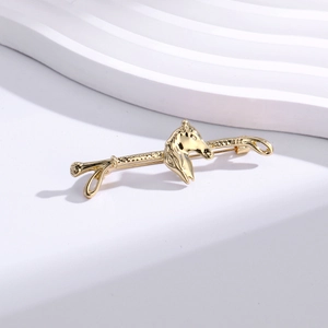 Detailed view of vintage gold horse head brooch pin on elegant geometric stone stand