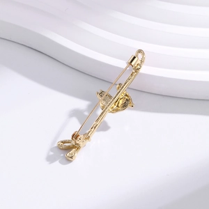 Vintage golden long metal horse brooch with intricate engraved texture on white waves