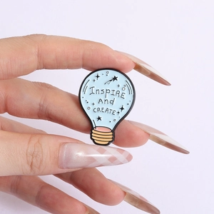 Light blue light bulb enamel pin with Inspire and Create slogan for creative accessories