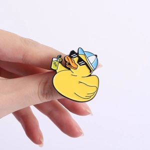 Detail einer Cartoon-Enten-Emaille-Anstecknadel mit Sonnenbrille und Getränk