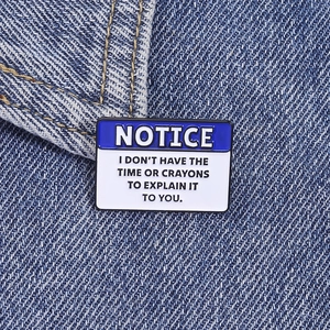 Detailed close-up of funny enamel pin on denim jacket with witty notice message