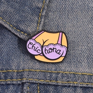 Quirky enamel brooch featuring a purple lingerie torso design on denim fabric