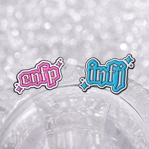 Detailed view of enamel MBTI pins featuring ENFP and INFJ letters on clear glass
