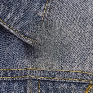 Détail du pin's émaillé Corgi avec slogan Short Legs Big Attitude sur veste en jean