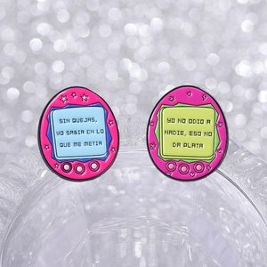 Détail des pin's émaillés Tamagotchi roses avec texte espagnol sur bord en verre