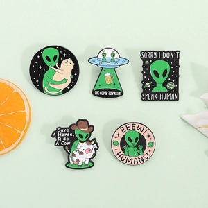 Detailed view of 5 alien enamel pins featuring funny UFO and green alien scenes