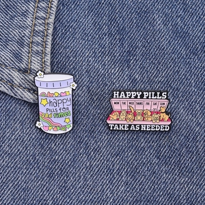 Whimsical Happy Pills enamel pin set featuring colorful rainbow dog designs on denim