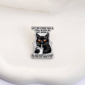 Detailaufnahme der Emaille-Anstecknadel mit schwarzer Katze, Zitronengetränk und Spruch