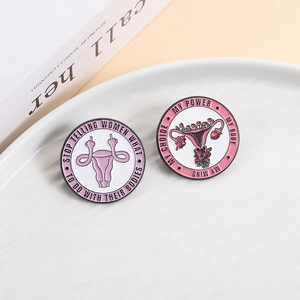 Detail of round enamel pins with feminist slogans on a white ceramic plate