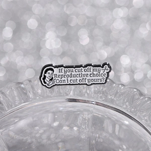 Macro detail of enamel pin with reproductive rights slogan on ribbed glass