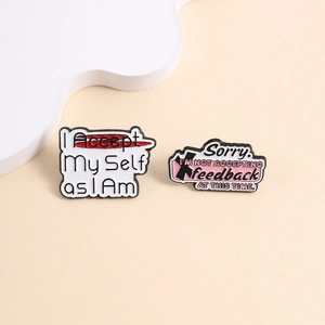 Detail of enamel lapel pins with self-acceptance and no feedback quote slogans