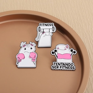 Detailed close-up of cartoon enamel pins featuring fitness themes and boxing gear