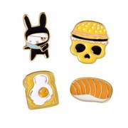 Detailed view of four enamel pins featuring creative rabbit, burger, and sushi designs
