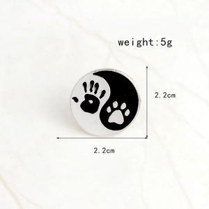 Detail view of 2.2cm round Yin Yang brooch with human hand and pet paw print design