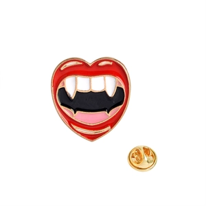 Detail view of heart-shaped vampire lips enamel pin with golden metal butterfly clutch