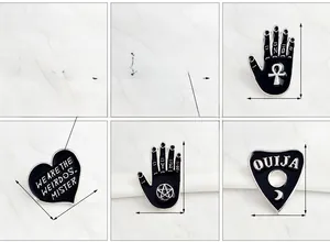 Detailed view of Gothic black enamel pins showing cursed text and witch hand motifs