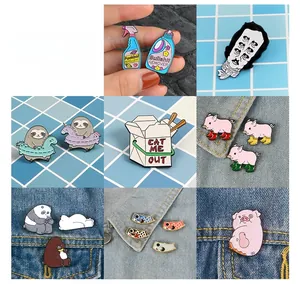 Collection of cartoon enamel pins including parody designs on denim fabric and plaid background