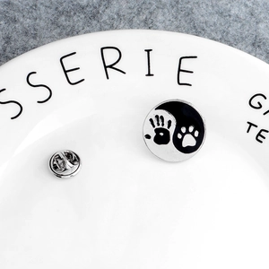 Creative Yin Yang pin with handprint and paw print design on white ceramic plate
