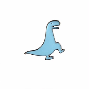 Détail macro du pin's émaillé dinosaure bleu clair avec des bordures en métal argenté