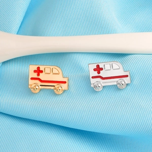 Vue détaillée des broches ambulance or et argent avec détails de croix rouge