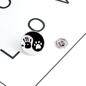 Yin Yang pin badge featuring human hand and pet paw prints in black and white enamel