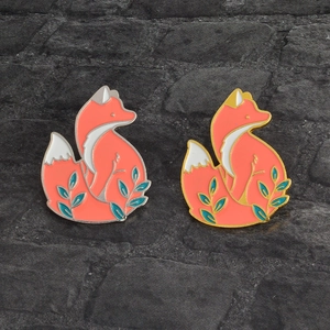 Détail de broches renard en émail doré et argenté aux couleurs orange vif éclatantes