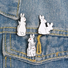 Detailed macro view of creative white rabbit enamel pins on blue denim fabric