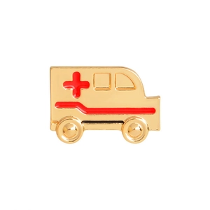 Détail macro de la broche ambulance en émail avec plaquage or et croix rouge