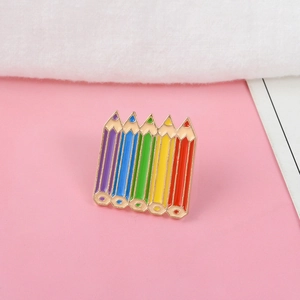 Broche en émail en forme de crayons arc-en-ciel avec finition polie sur fond rose