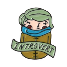 Detail of cartoon enamel pin with introvert text banner on white background