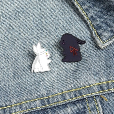 Detail view of black and white enamel bunny badges on blue denim background