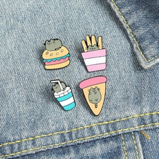 Detailed view of four cartoon cat fast food enamel pins pinned on blue denim fabric