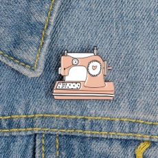 Rosa Vintage Nähmaschinen Emaille Anstecknadel mit Herzdetail auf blauem Denim