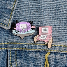 Close-up of retro console enamel pins featuring purple and pink handheld game designs