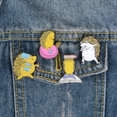 Detailed view of four cute hedgehog enamel pins styled on blue denim fabric pockets