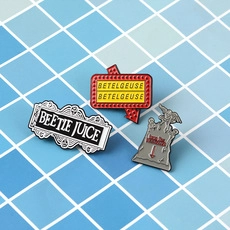 Detailaufnahme von Emaille-Pins Set mit Film-inspirierten Grabstein- und Schilddesigns