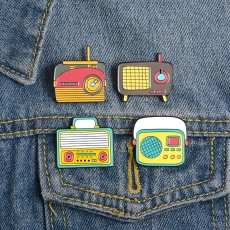 Set of four colorful retro radio enamel pins on blue denim jacket pocket