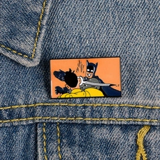 Dettaglio della spilla smaltata Batman che schiaffeggia Robin su giacca di jeans