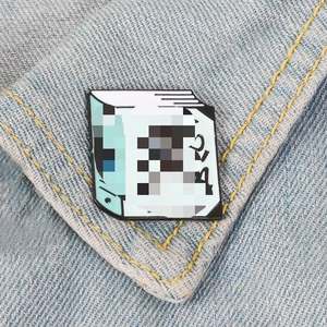 Broche mignonne en émail en forme de livre bleu sur un fond de tissu en jean