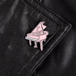 Rosa Flügel-Emaille-Pin-Anstecker auf dem Kragen einer schwarzen Lederjacke