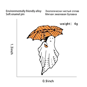 Detail view of ghost enamel pin with orange striped umbrella and precise size markings