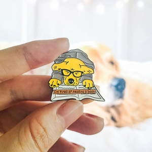 Détail d'un badge émaillé avec un chiot et le texte I'm tired of reading a book