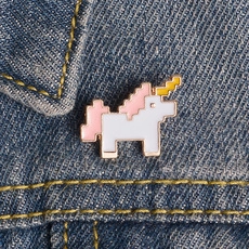 Vue détaillée d'un pin's licorne en émail pixel art sur un tissu en jean bleu