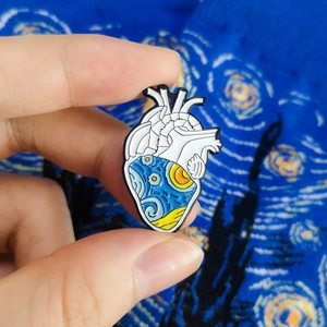 Artistic enamel pin showing an anatomical heart featuring Van Gogh's Starry Night painting