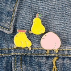 Détail de broches en émail aux motifs de fruits anthropomorphes, banane, poire et pêche